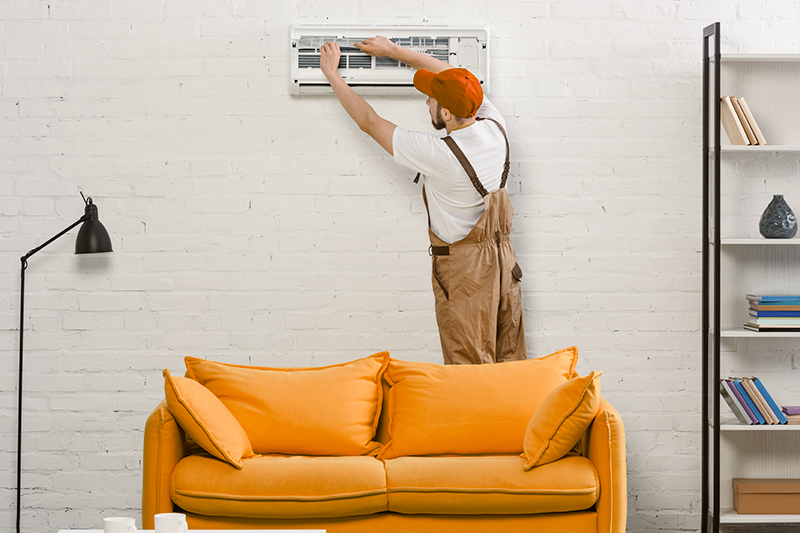 Profissional instalando ar-condicionado em casa.